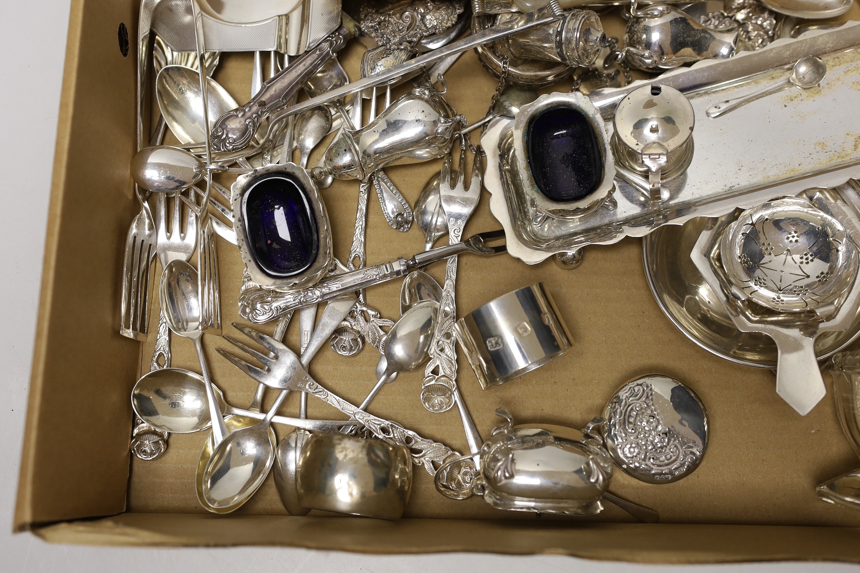 Sundry small silver wares including a cigarette case, two tea strainers, assorted flatware and a condiment set.